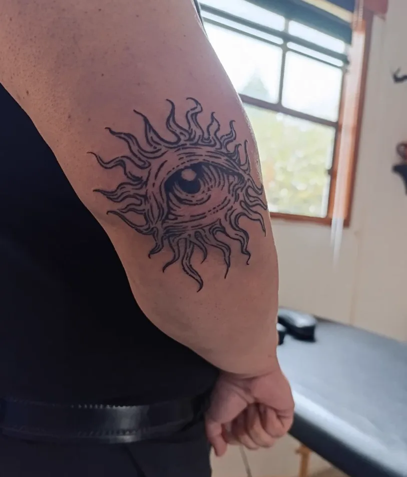 Sol con ojo en línea sobre codo